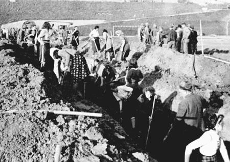 German civilians are forced to dig a pit